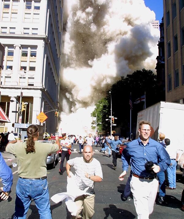 Mọi người chạy ra khỏi tòa tháp cao đang sụp xuống của Trung tâm Thương mại Thế giới trong vụ khủng bố 11 tháng Chín tại New York - Sputnik Việt Nam