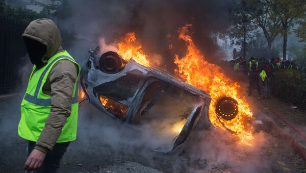 Chiếc xe bị đốt cháy trong phong trào biểu tình phản đối áo ghi lê vàng ở Paris - Sputnik Việt Nam