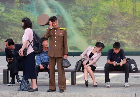 Những người dân thành phố đứng ở bến đợi xe buýt tại Bình Nhưỡng - Sputnik Việt Nam