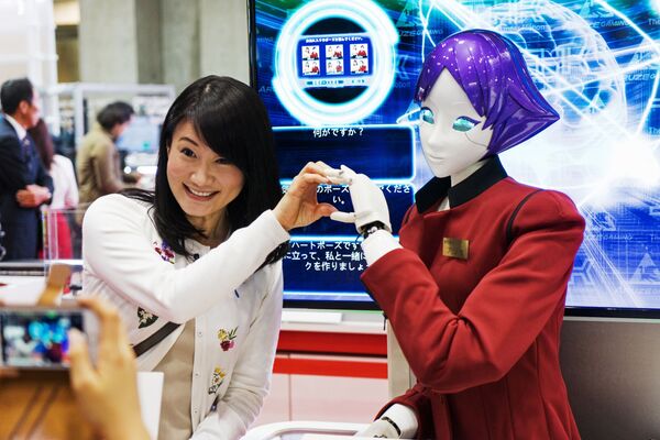 Một nữ du khách chụp ảnh với robot FASHION Junko Koshino tại triển lãm quốc tế về robot IREX ở Tokyo - Sputnik Việt Nam