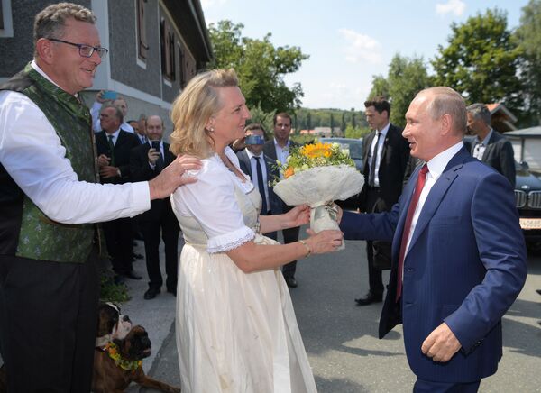 Tổng thống Nga Vladimir Putin tặng cho bà Karin Kneissl một bó hoa khi đến dự hôn lễ của bà với doanh nhân Wolfgang Meilinger tại làng Gamlitz ở Styria, Áo vào ngày 18 tháng 8 năm 2018. - Sputnik Việt Nam