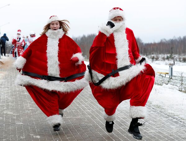 Cặp đôi người Belarus trong trang phục ông già Noel tham gia cuộc thi chạy quanh hồ nhân dịp năm mới ở Minsk, Belarus - Sputnik Việt Nam