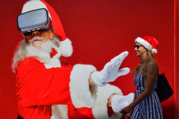 Cô gái đi ngang qua tấm áp phích có hình ông già Noel ở Dubai - Sputnik Việt Nam