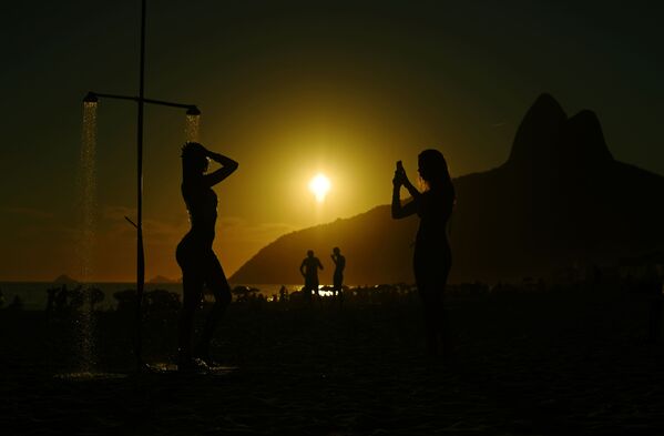 Khách du lịch trên nền hoàng hôn trên bãi biển Ipanema ở Rio de Janeiro - Sputnik Việt Nam