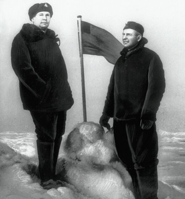 Chỉ huy tàu ngầm hạt nhân Leninsky Komsomol Lev Zhiltsov và phó chính ủy A. Shturmanov bên lá cờ mà họ cắm gần Bắc Cực Chỉ huy tàu ngầm hạt nhân Leninsky Komsomol Lev Zhiltsov và phó chính ủy A. Shturmanov bên lá cờ mà họ cắm gần Bắc Cực - Sputnik Việt Nam