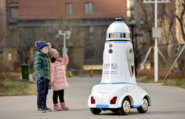 Trẻ em cạnh robot tuần tra trên đường phố thành phố Hohhot, Nội Mông, Trung Quốc - Sputnik Việt Nam