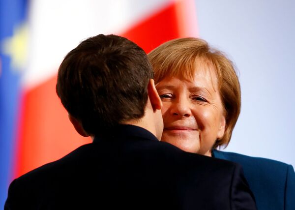 Thủ tướng Đức Angela Merkel ôm hôn Tổng thống Pháp Emmanuel Macron sau khi ký thỏa thuận hợp tác song phương - Sputnik Việt Nam