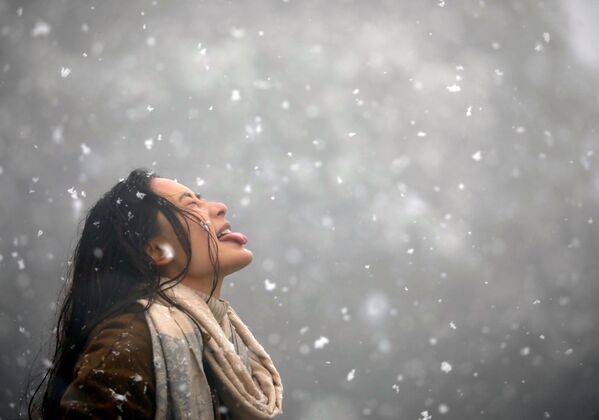 Cô gái dùng miệng hứng tuyết trong khi tuyết rơi ở Kathmandu, Nepal - Sputnik Việt Nam