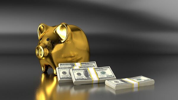 Золотая свинья-копилка рядом с пачками долларовых купюр - Sputnik Việt Nam