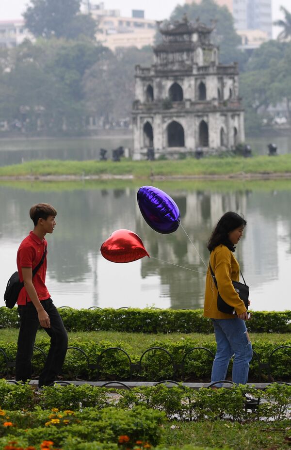 Đôi uyên ương cầm bóng bay hình trái tim trong công viên nhân ngày Valentine tại Hà Nội, Việt Nam - Sputnik Việt Nam