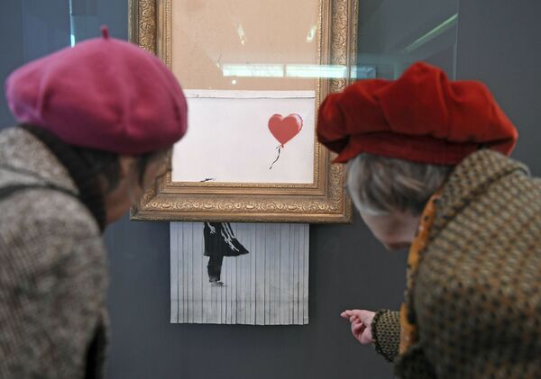Du khách xem bức tranh tự hủy sau khi bán đấu giá Cô gái với khinh khí cầu của Banksy, giờ được gọi là Tình yêu trong thùng rác, Bảo tàng Nghệ thuật Đương đại Baden-Baden, Đức - Sputnik Việt Nam