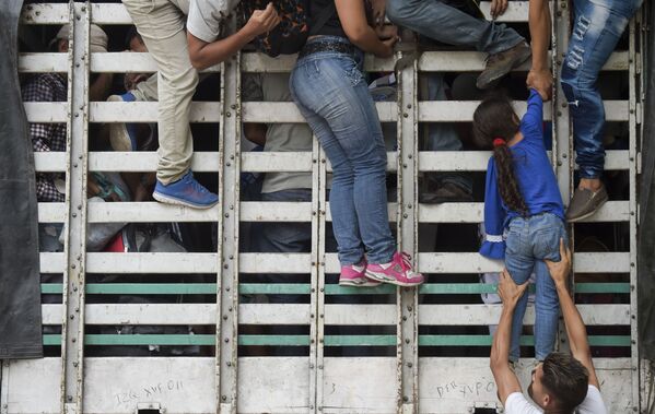 Người di cư Venezuela leo lên chiếc xe tải trên đường từ Cucuta đến Pamplona, Colombia - Sputnik Việt Nam