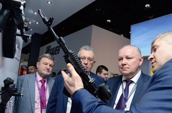 Tổng giám đốc Công ty Cổ phần Rosoboronexport Alexander Mikheev (thứ hai từ phải sang) xem xét khẩu súng trường tấn công Kalashnikov loại 200 tại triển lãm vũ khí quốc tế IDEX-2019 ở Abu Dhabi - Sputnik Việt Nam