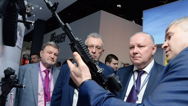 Tổng giám đốc Công ty Cổ phần Rosoboronexport Alexander Mikheev (thứ hai từ phải sang) xem xét khẩu súng trường tấn công Kalashnikov loại 200 tại triển lãm vũ khí quốc tế IDEX-2019 ở Abu Dhabi - Sputnik Việt Nam