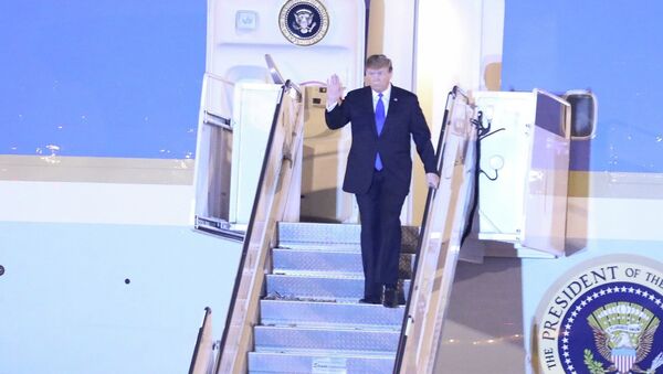 Tổng thống Mỹ Donald Trump vừa xuống cầu thang máy bay vừa vẫy tay chào các đại biểu và người dân Thủ đô ra đón tại sân bay quốc tế Nội Bài. - Sputnik Việt Nam