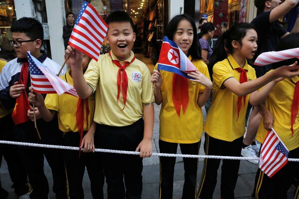 Trẻ em cầm cờ Mỹ và CHDCND Triều Tiên tại khách sạn Sofitel Legend Metropole trước cuộc gặp của Tổng thống Mỹ Donald Trump với nhà lãnh đạo Triều Tiên Kim Jong-un tại Hà Nội - Sputnik Việt Nam