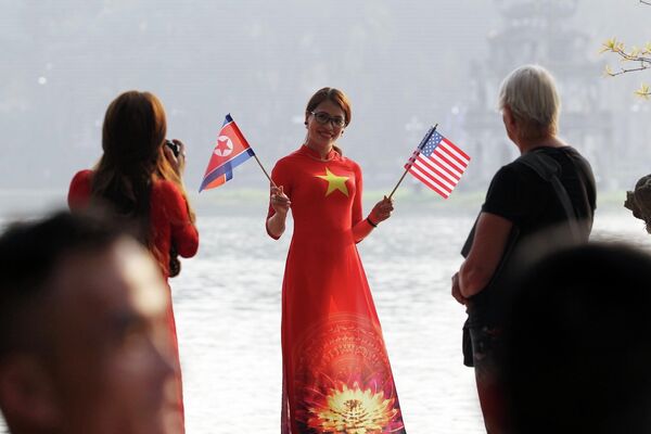Thiếu nữ Việt Nam cầm cờ Mỹ và Triều Tiên chào mừng hội nghị. - Sputnik Việt Nam