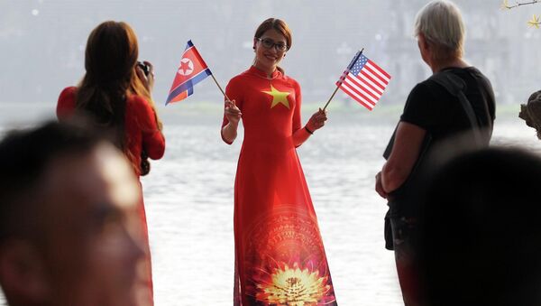 Thiếu nữ Việt Nam cầm cờ Mỹ và Triều Tiên chào mừng hội nghị.  - Sputnik Việt Nam