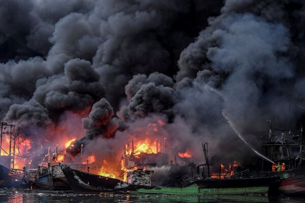 Lính cứu hỏa dập lửa trên các tàu đánh cá đang bốc cháy tại cảng Muara Baru ở Jakarta, Indonesia - Sputnik Việt Nam