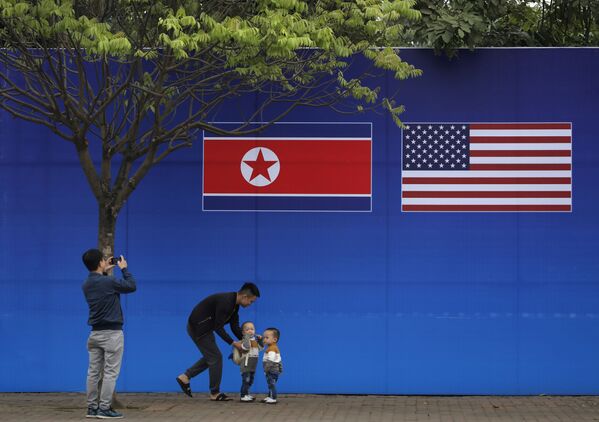 Cư dân Hà Nội tạo dáng trước hình ảnh lá cờ Bắc Triều Tiên và Mỹ trong những ngày diễn ra hội nghị thượng đỉnh Bắc Triều Tiên-Mỹ tại Hà Nội - Sputnik Việt Nam