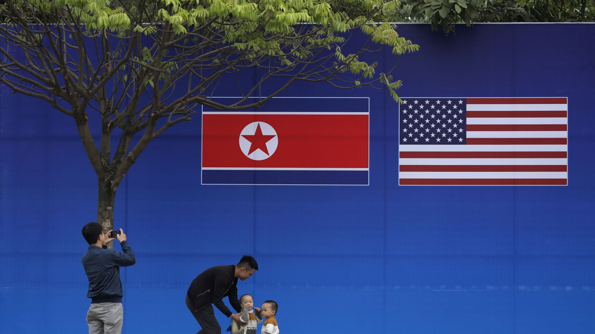 Cư dân Hà Nội tạo dáng trước hình ảnh lá cờ Bắc Triều Tiên và Mỹ trong những ngày diễn ra hội nghị thượng đỉnh Bắc Triều Tiên-Mỹ tại Hà Nội - Sputnik Việt Nam, 1920, 22.05.2022