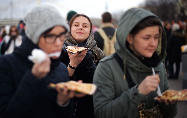 Các cô gái ăn bánh xèo trong lễ hội Maslenitsa ở Công viên Gorky, Moskva - Sputnik Việt Nam
