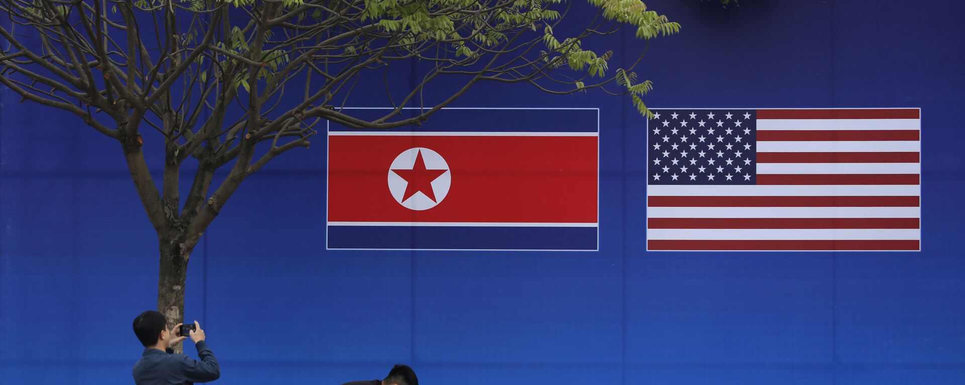 Cư dân Hà Nội tạo dáng trước hình ảnh lá cờ Bắc Triều Tiên và Mỹ trong những ngày diễn ra hội nghị thượng đỉnh Bắc Triều Tiên-Mỹ tại Hà Nội - Sputnik Việt Nam, 1920, 07.01.2022