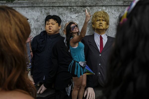 Cô gái chụp ảnh selfie bên cạnh những con búp bê hình Tổng thống Mỹ Donald Trump và nhà lãnh đạo Triều Tiên Kim Jong-un trong lễ hội ở Olinda, Brazil - Sputnik Việt Nam