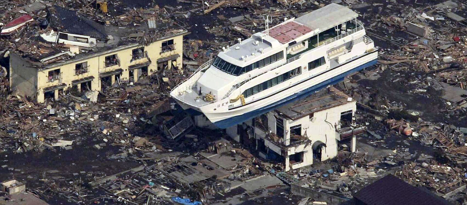 Du thuyền trên nóc tòa nhà ở thành phố Otsuchi sau trận động đất và sóng thần ngày 11 tháng 3 năm 2011 tại Nhật Bản - Sputnik Việt Nam, 1920, 11.03.2019