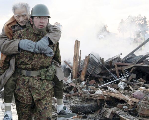 Quân nhân cõng trên mình người dân bị ảnh hưởng bởi trận động đất và sóng thần 2011 tại Nhật Bản - Sputnik Việt Nam