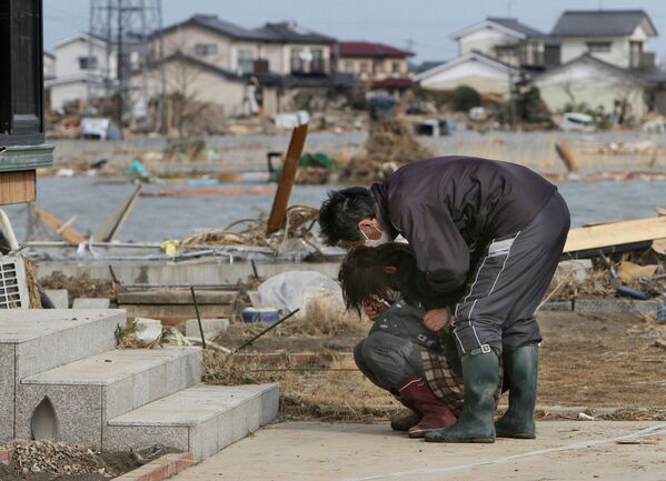 Người dân tại ngôi nhà bị phá hủy của họ ở thành phố Watari sau trận động đất và sóng thần tấn công đất nước Nhật Bản ngày 11 tháng 3 năm 2011 - Sputnik Việt Nam