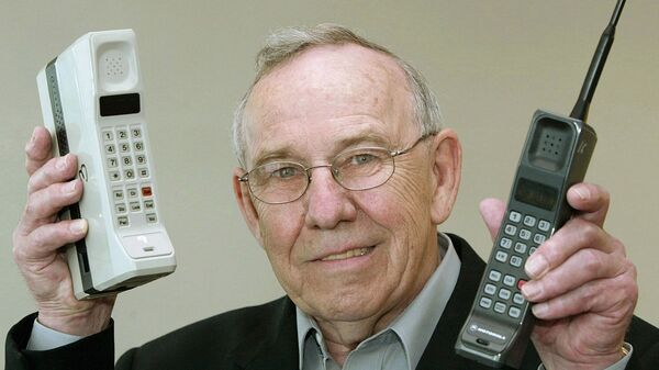 Cựu lãnh đạo Motorola Design Rudi Krolopp với điện thoại di động đầu tiên DynaTAC 8000X và điện thoại di động đầu tiên International 3200, năm 2003 - Sputnik Việt Nam