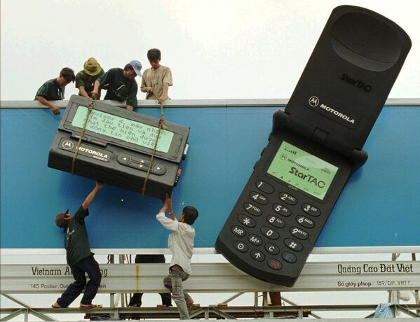 Công nhân lắp đặt máy nhắn tin khổng lồ bên cạnh chiếc điện thoại di động khổng lồ với quảng cáo sản phẩm viễn thông của hãng Motorola tại Thành phố Hồ Chí Minh, năm 1996 - Sputnik Việt Nam