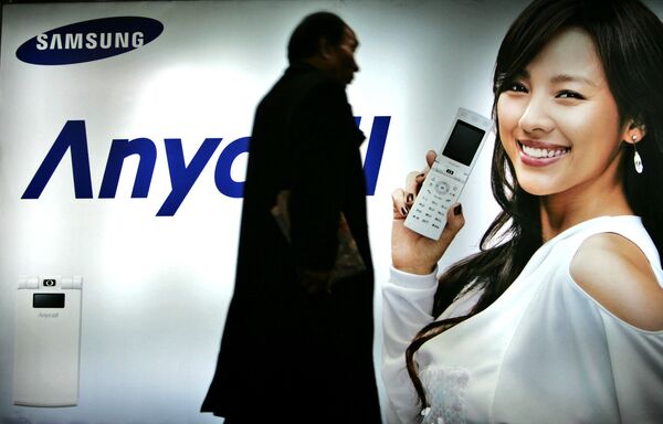 Khách bộ hành đi ngang qua biển quảng cáo Samsung Mobile ở Seoul, Hàn Quốc, năm 2007 - Sputnik Việt Nam