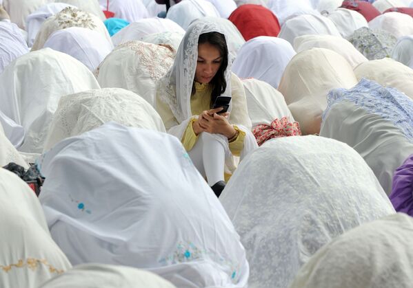 Người phụ nữ Hồi giáo với chiếc điện thoại di động giữa những người cầu nguyện trong lễ Eid al-Adha ở Jakarta - Sputnik Việt Nam
