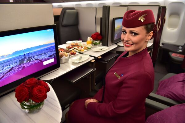 Tiếp viên hàng không Qatar Airways trong khoang hạng thương gia trên máy bay Boeing 777 - Sputnik Việt Nam