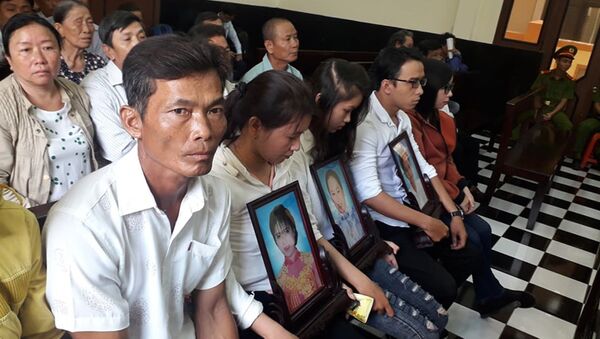 Người thân của các nạn nhân mang di ảnh đến dự phiên tòa.  - Sputnik Việt Nam