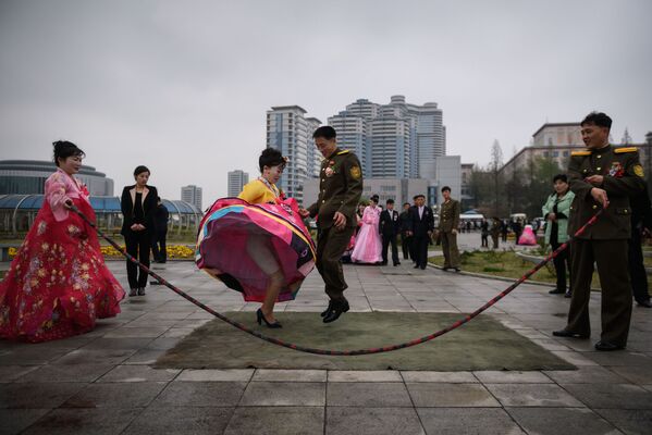 Cặp vợ chồng mới cưới  chơi nhảy dây trong buổi chụp ảnh cưới ở Bình Nhưỡng, Triều Tiên - Sputnik Việt Nam