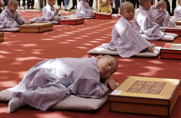 Cậu bé ngủ trưa sau buổi lễ xuống tóc quy y trong dịp Phật đản lần thứ 2563 sắp tới tại chùa Jogee ở Seoul, Hàn Quốc - Sputnik Việt Nam