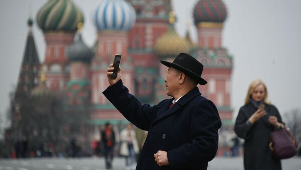 Турист фотографируется на Красной площади в Москве, на фоне храма Василия Блаженного - Sputnik Việt Nam