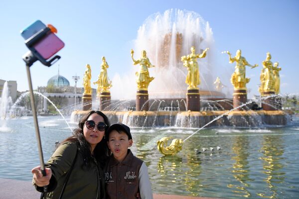 Khách du lịch chụp ảnh tại đài phun nước  “Tình hữu nghị của các dân tộc” trong Triển lãm Thành tựu Kinh tế Quốc dân (VDNKh) ở Matxcơva  - Sputnik Việt Nam