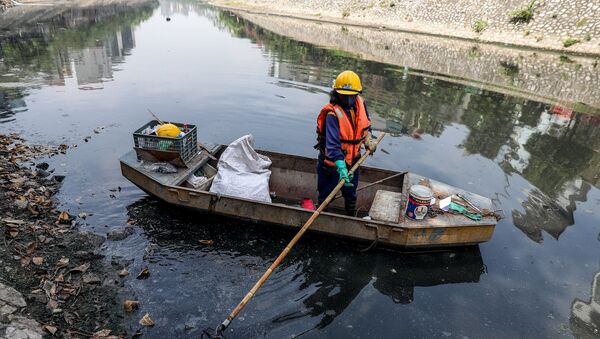 Các công nhân vệ sinh phải thường xuyên thu dọn rác thải trên bề mặt sông - Sputnik Việt Nam