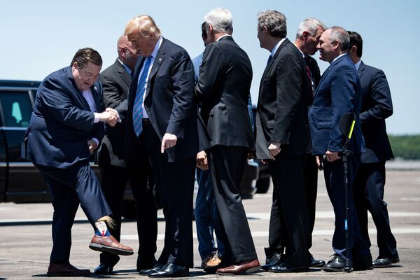 Phó thống đốc bang Louisiana Billy Nungesser khoe với Tổng thống Donald Trump đôi tất dệt chân dung của ông tại sân bay Lake Charles - Sputnik Việt Nam