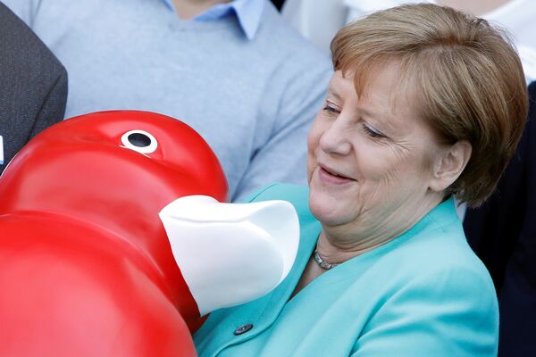 Thủ tướng Đức Angela Merkel giữ trong tay một con vịt, mà bà được  tặng trong chuyến thăm công ty Centogene ở thành phố Rostock - Sputnik Việt Nam