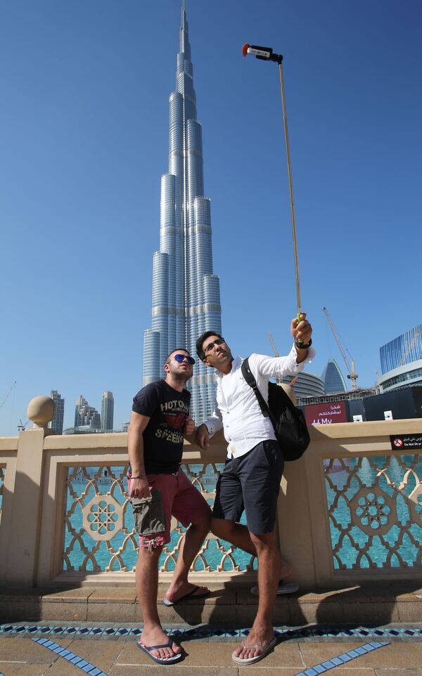 Khách du lịch đến từ Azerbaijan chụp ảnh trước tòa nhà chọc trời Burj Khalifa ở Dubai - Sputnik Việt Nam