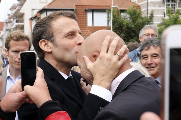 Tổng thống Pháp Emmanuel Macron hôn người ủng hộ sau khi bỏ phiếu trong cuộc bầu cử Nghị viện châu Âu tại Le Touquet ở miền bắc nước Pháp - Sputnik Việt Nam