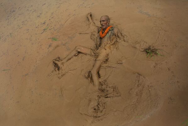 Người đàn ông cao tuổi tắm bùn trong ngày lễ trồng lúa Asar Pandra ở Nepal - Sputnik Việt Nam