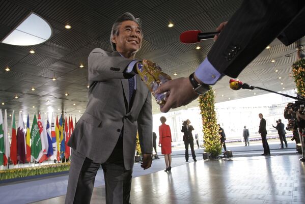 Bộ trưởng Ngoại giao Nhật Bản Hirofumi Nakasone lấy một thanh sô cô la từ gói của phóng viên kênh truyền hình Hà Lan tại hội nghị ở The Hague, Hà Lan - Sputnik Việt Nam