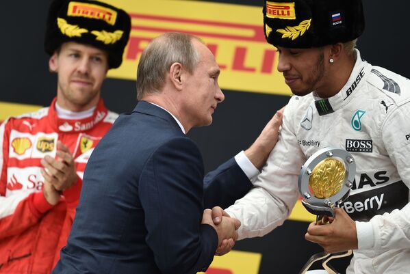 Tổng thống Nga Vladimir Putin trao Cúp “Grand Prix Nga” cho tay đua của đội “Mercedes” Lewis Hamilton, người giành vị trí số 1 trong chặng đua ở Nga của Giải Vô địch đua xe Thế giới “Công thức 1” ở đường đua Sochi. - Sputnik Việt Nam