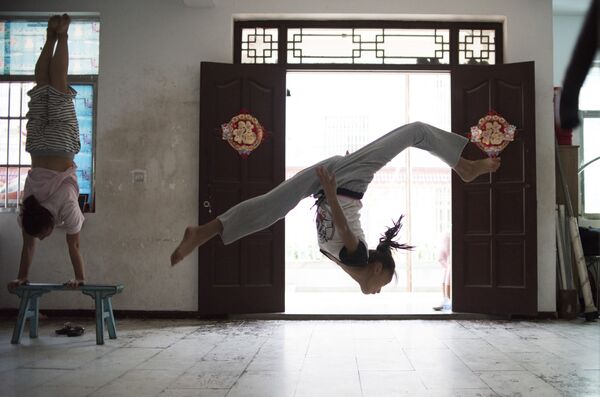 Một cô gái trong đội nhào lộn của Đoàn Xiếc Thượng Hải Shanghai Dream acrobatic biểu diễn một động tác nhào lộn trong buổi tập. - Sputnik Việt Nam